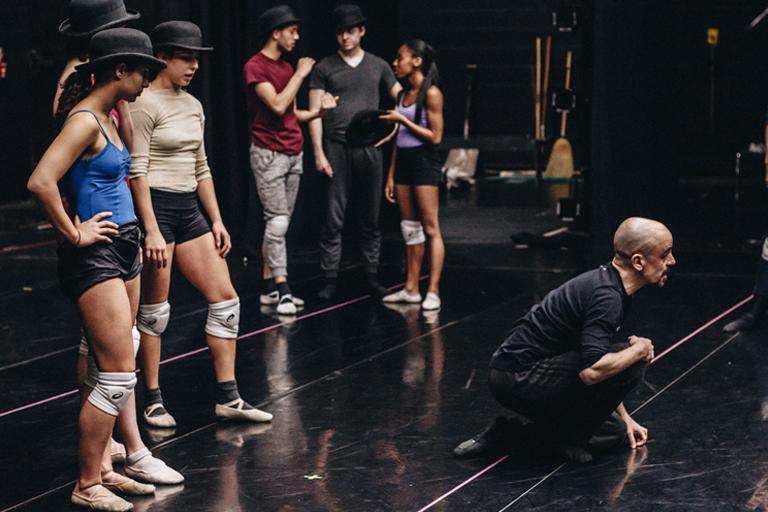 Sophia Bonacorso and Athena Nikolakopoulos watch Goyo Montero as he shows how to get up gracefully from a floor position.