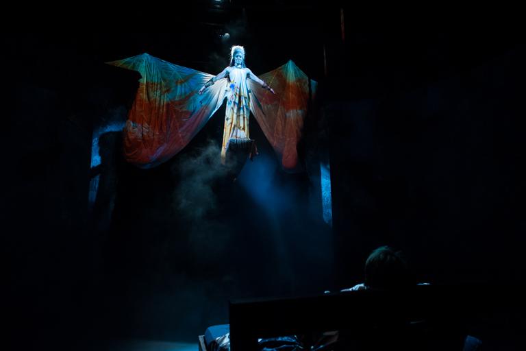 Stage automation graduate students flying a performer in the "Angels in America" drama production.