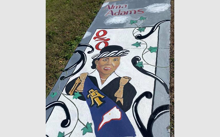 Murals painted on sidewalks, benches and picnic tables in the Kings Forest neighborhood in November 2021. / Photos: Ryan Deal