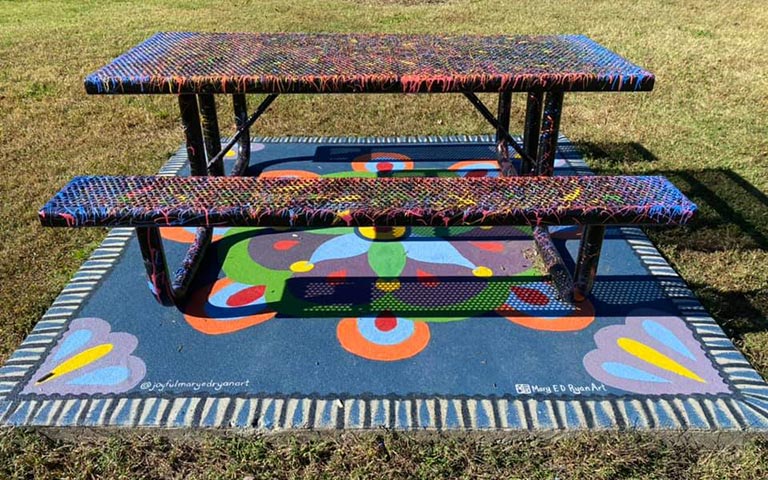 Murals painted on sidewalks, benches and picnic tables in the Kings Forest neighborhood in November 2021. / Photos: Ryan Deal