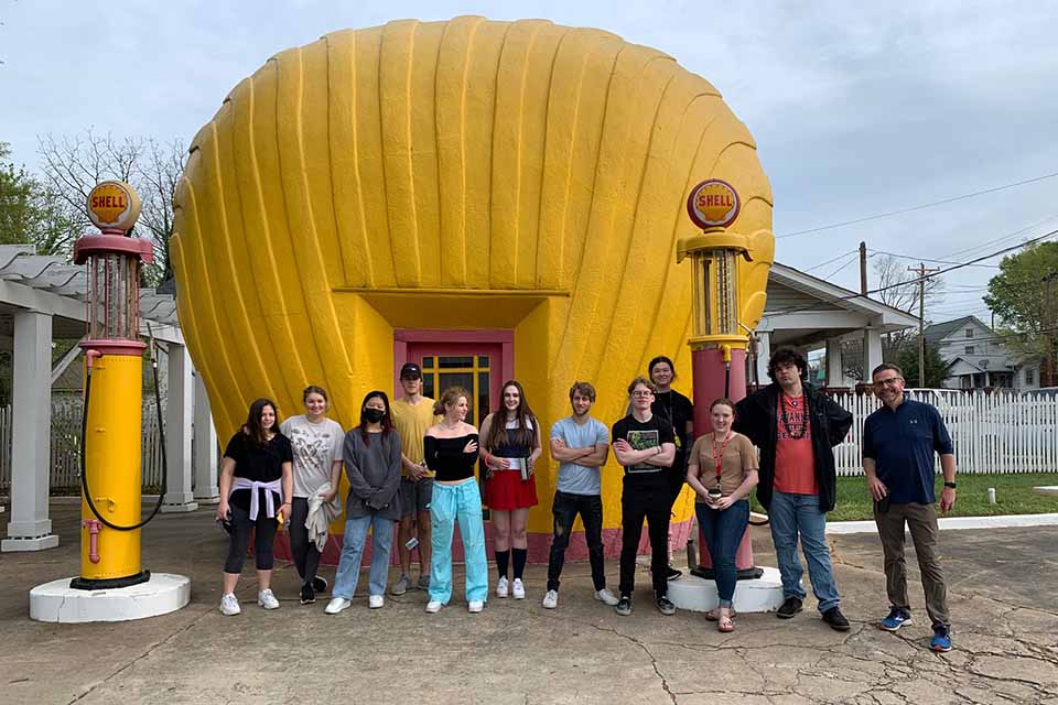 Division of Liberal Arts faculty Joe Mills and Mike Wakeford offer an elective course designed to break the typical student routine by taking weekly walks to points of interest and inspiration. Here they are at the Vintage Shell Station near campus. / Photo: Joe Mills 
