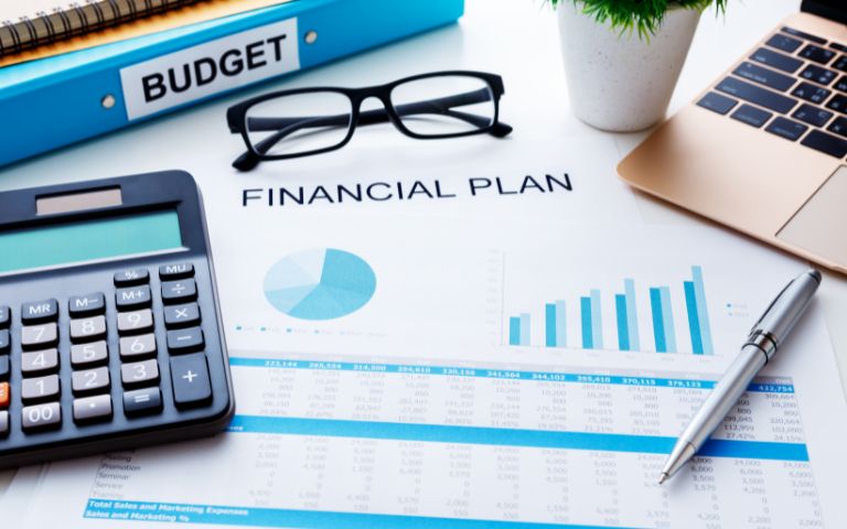 Financial planning graphs and charts adorn a table. 