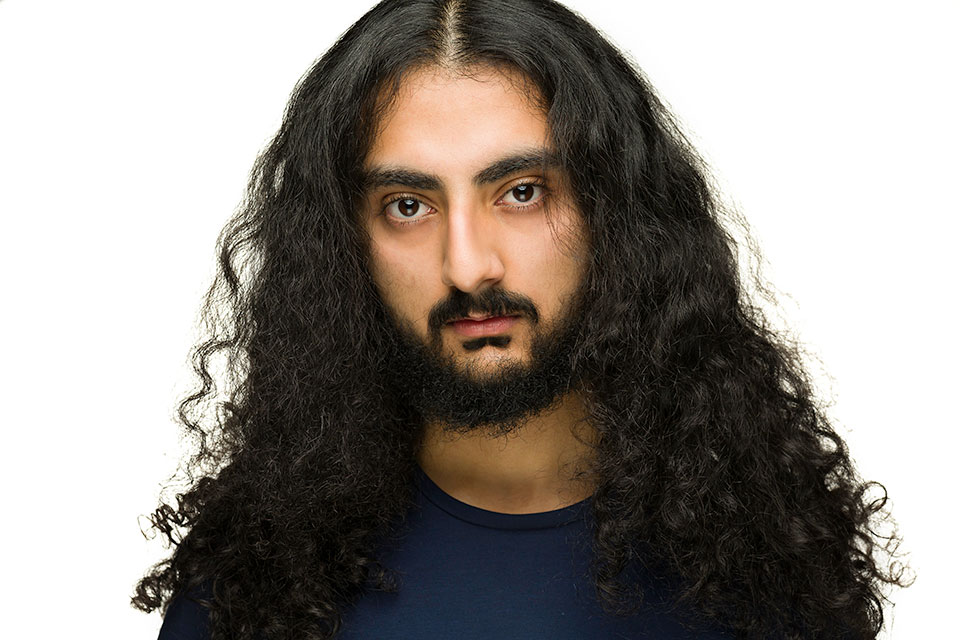 Headshot, hair over shoulders, dark shirt