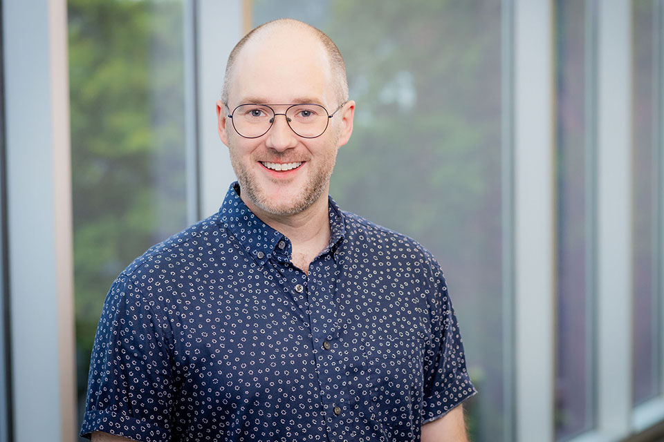 Brett Radke posing in front of windows