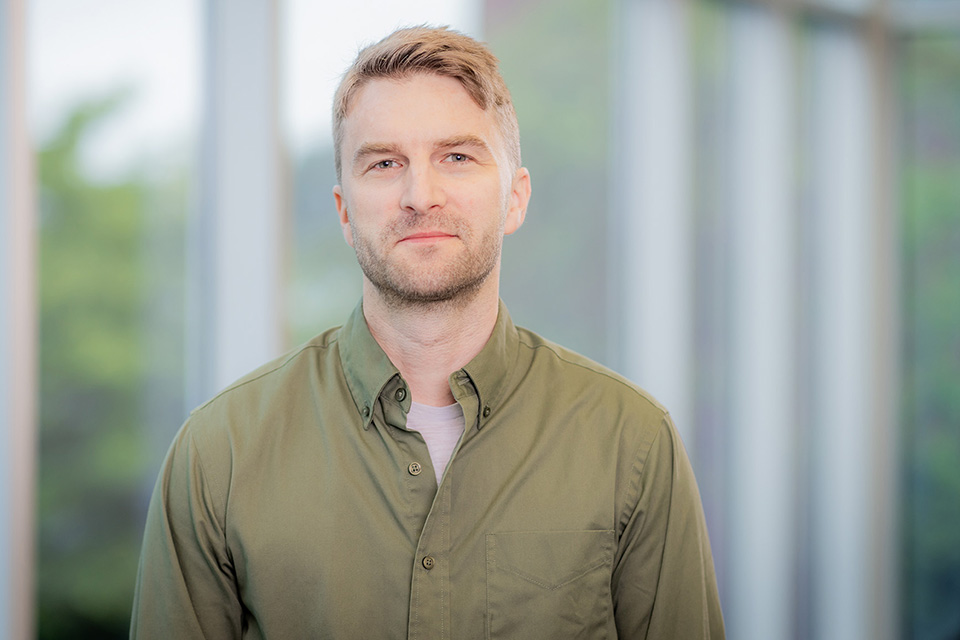 Jethro Waters poses in front of windows