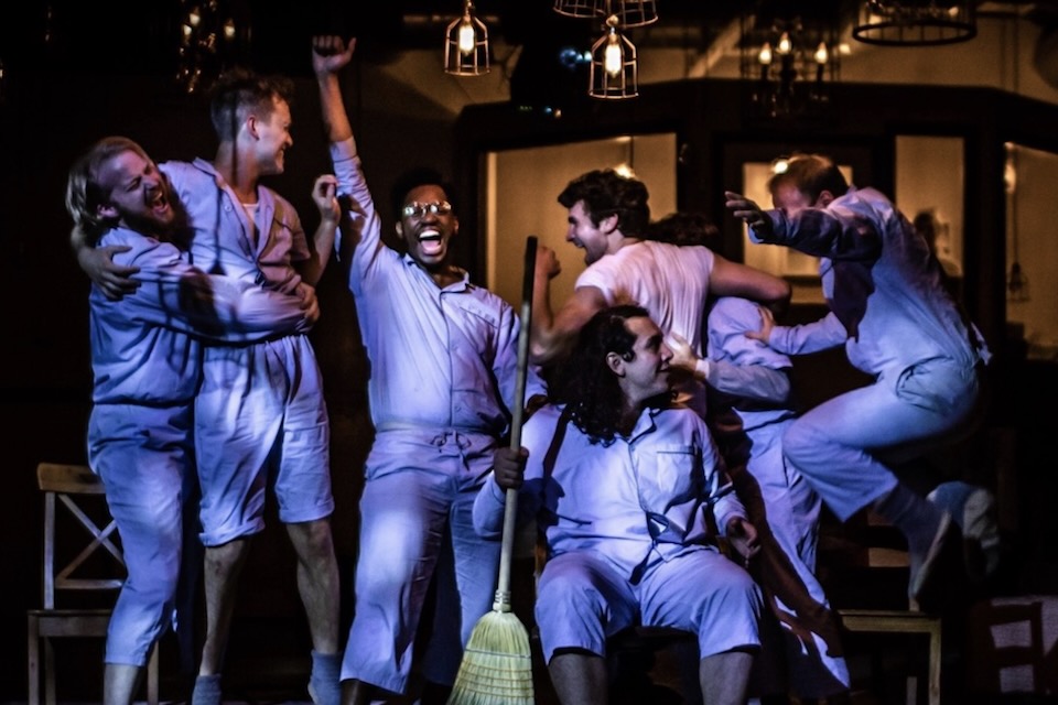 Actors in hospital patient attire dancing on stage.