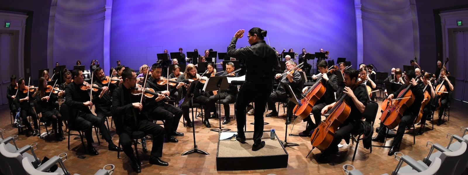 A Latina woman conducting and orchestra