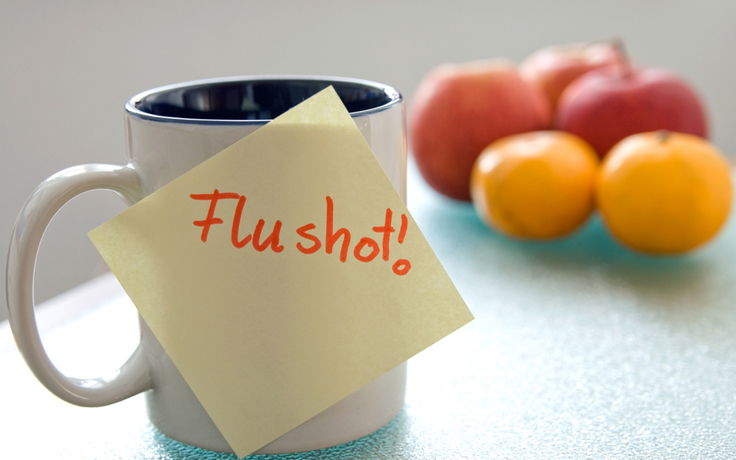 Flu shot sticky note on coffee mug