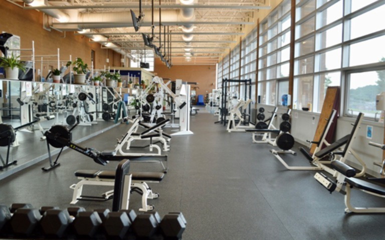 a wide shot of the UNCSA fitness center, showing exercise equipment and weights