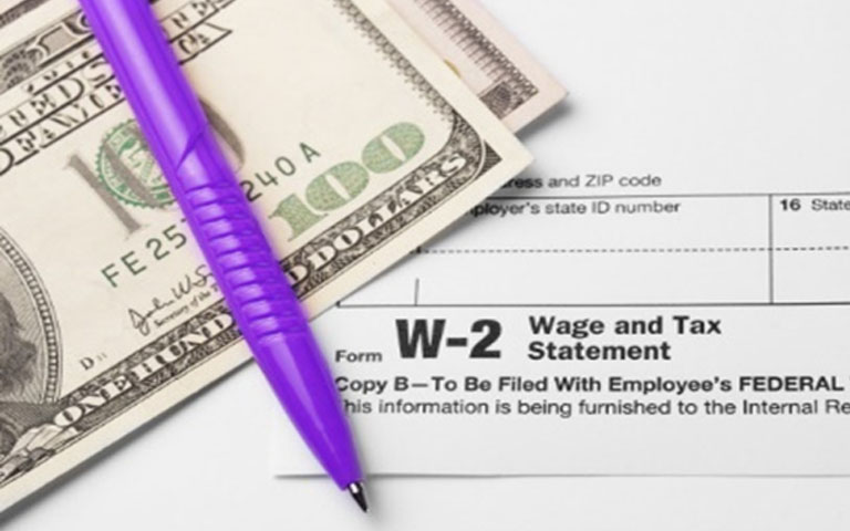 w-2 form with $100 bills atop