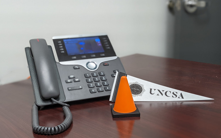 Campus desk phone with a construction cone nearby