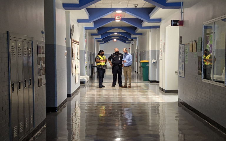 Clarisse Davis, Frank Brinkley and Martin Ferrell in a darken high school hallway.