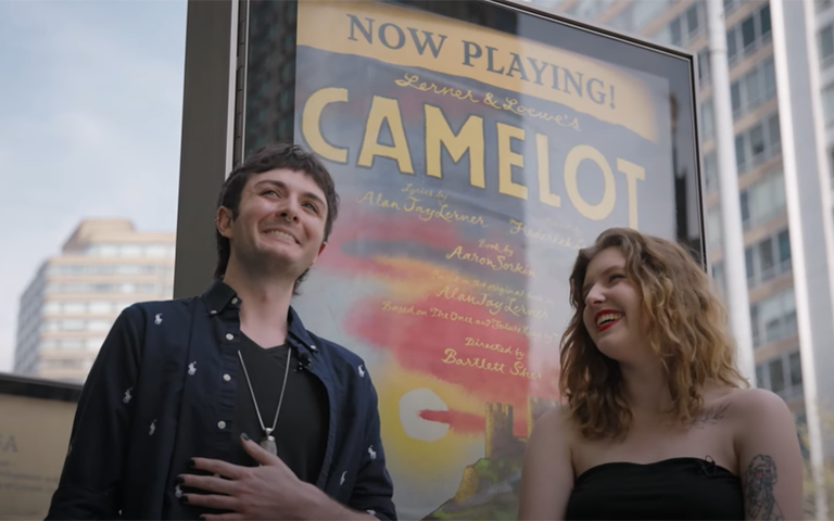 Amelia Brown and Harley Haberman in front of the Camelot sign in New York City.