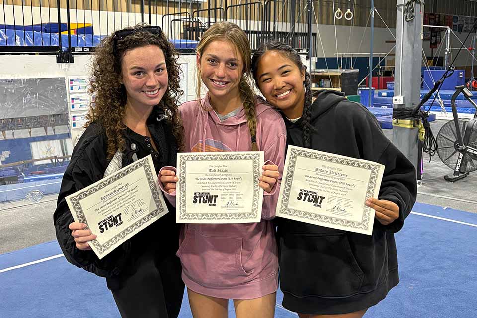 Hannah and two other students show their stunt school certifications