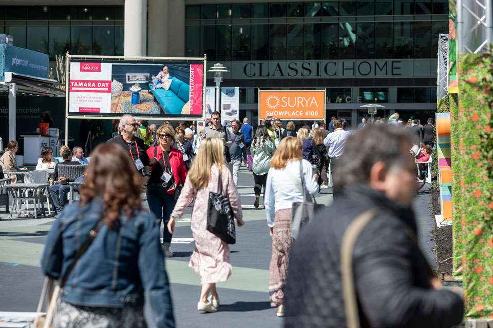 Crowds of pedestrians navigate a city street, passing a prominent sign that captures attention with its bold message. 