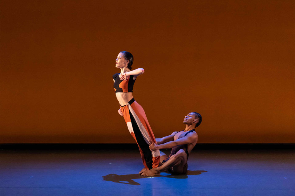 Two dancers performing gracefully on stage during a captivating dance performance.