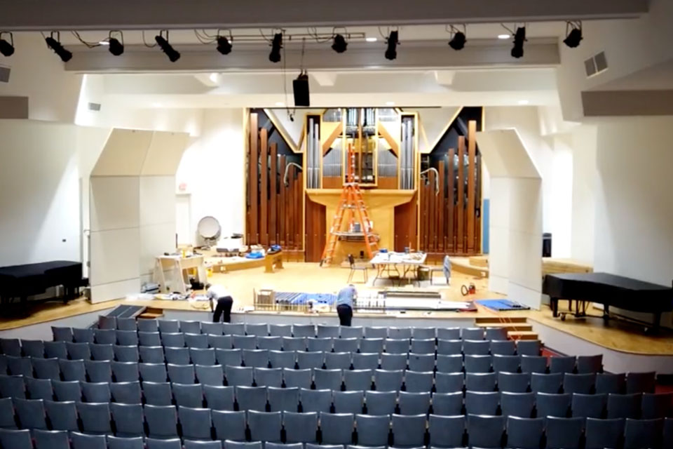 An expansive auditorium showcasing a large organ alongside an organ, designed for musical events and performances. 