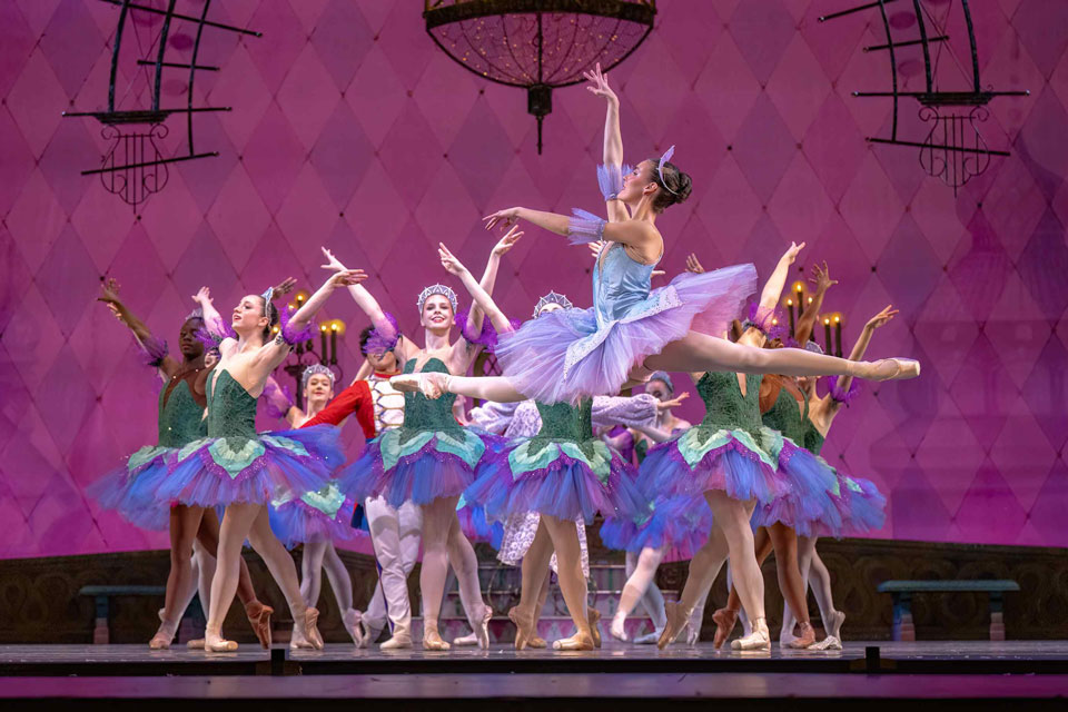 The Nutcracker, featuring dancers in festive costumes on a beautifully decorated stage.
