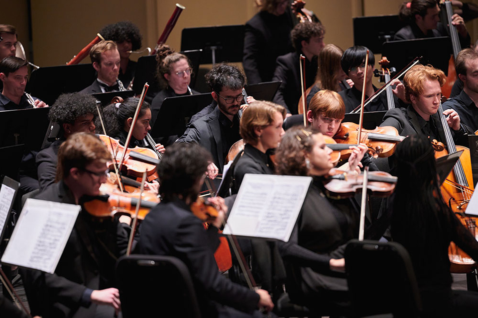 A monochrome photo featuring a group of people holding musical instruments.