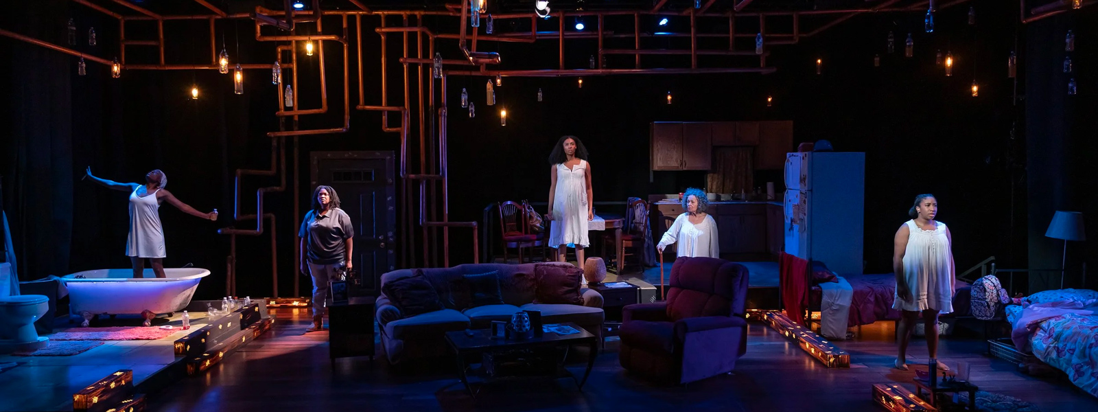 A stage show set with performers and an audience engaged in the performance.