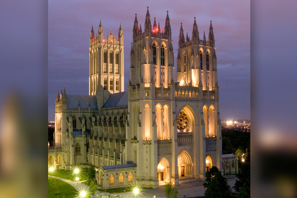 The cathedral illuminated at night, showcasing its architectural details against a dark sky.