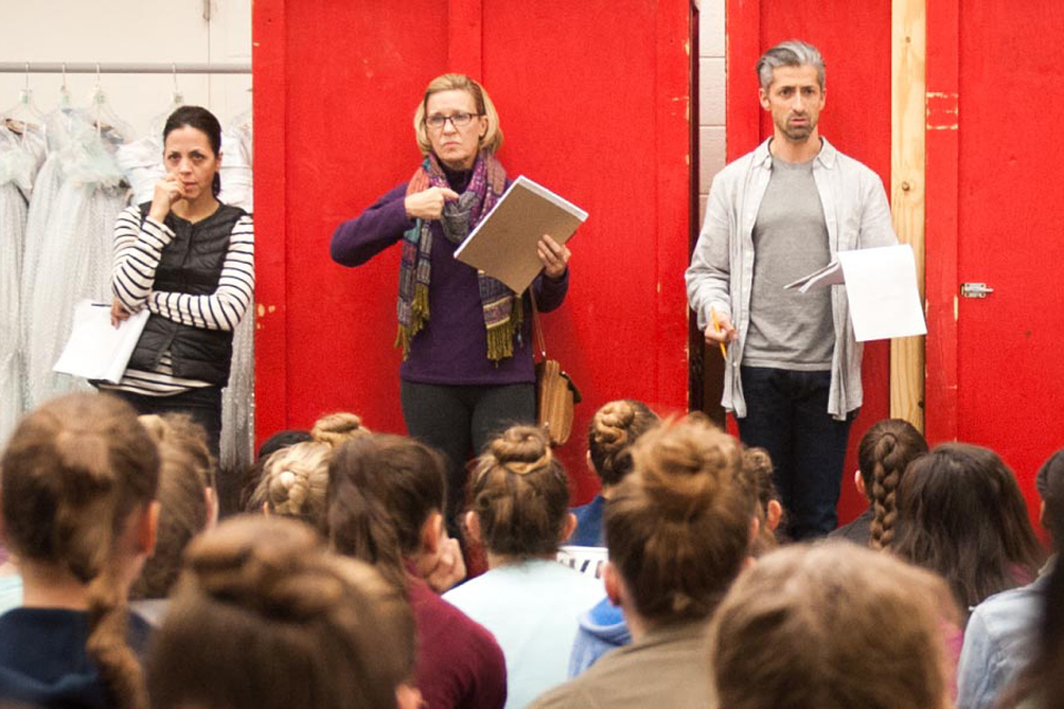Several individuals gather in front of a vibrant red door, showcasing a sense of community and camaraderie.