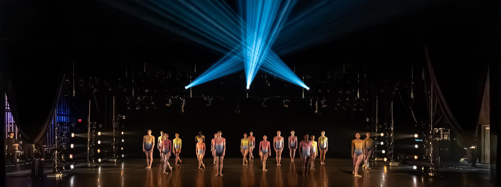 Dancers on a stage with dramatic lighting in the background